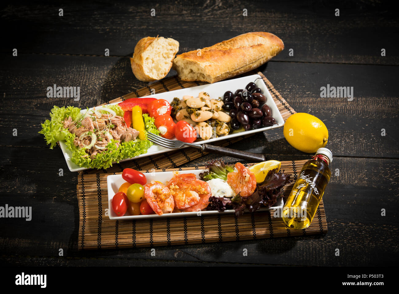 Antipasti, tuna, salad, filled paprika, white beans, black olive, shrimp, sour cream, tomato and white bread Stock Photo