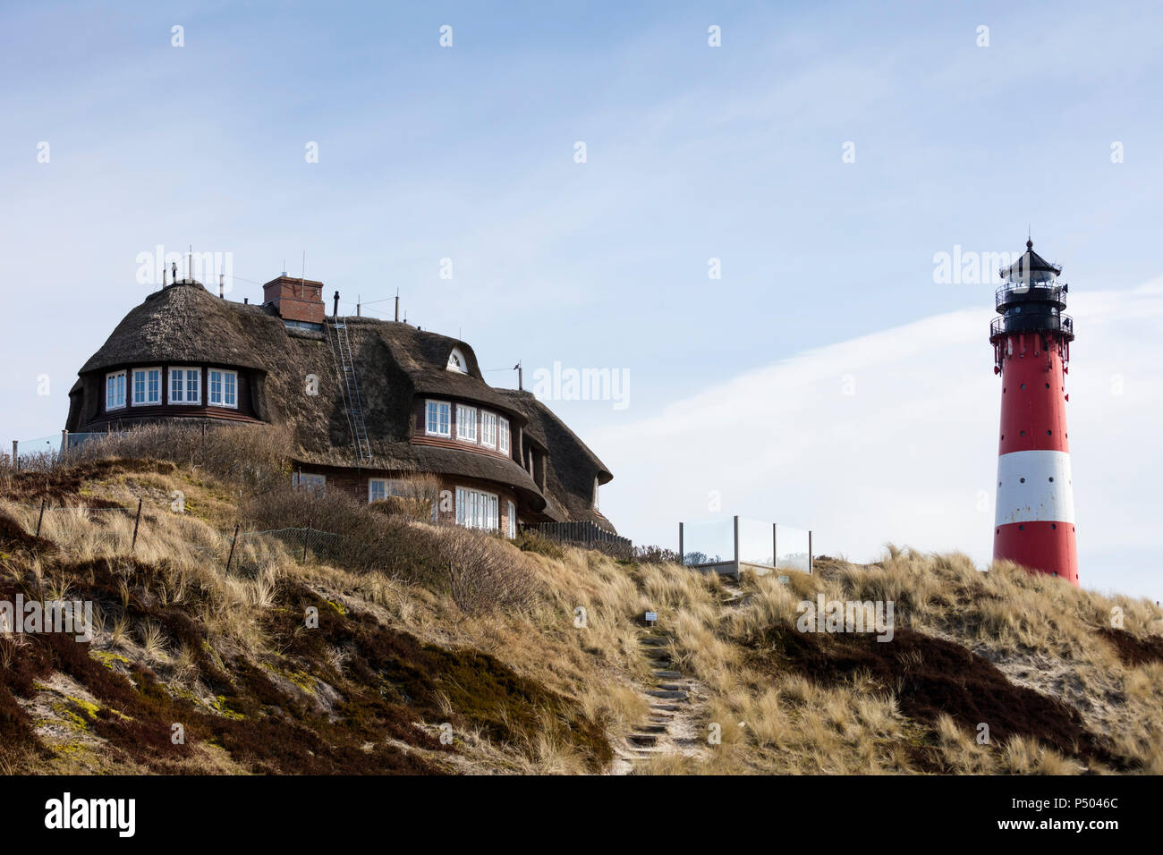 Germany, Schleswig-Holstein, Sylt, Hoernum, thatched-roof house and light house Stock Photo
