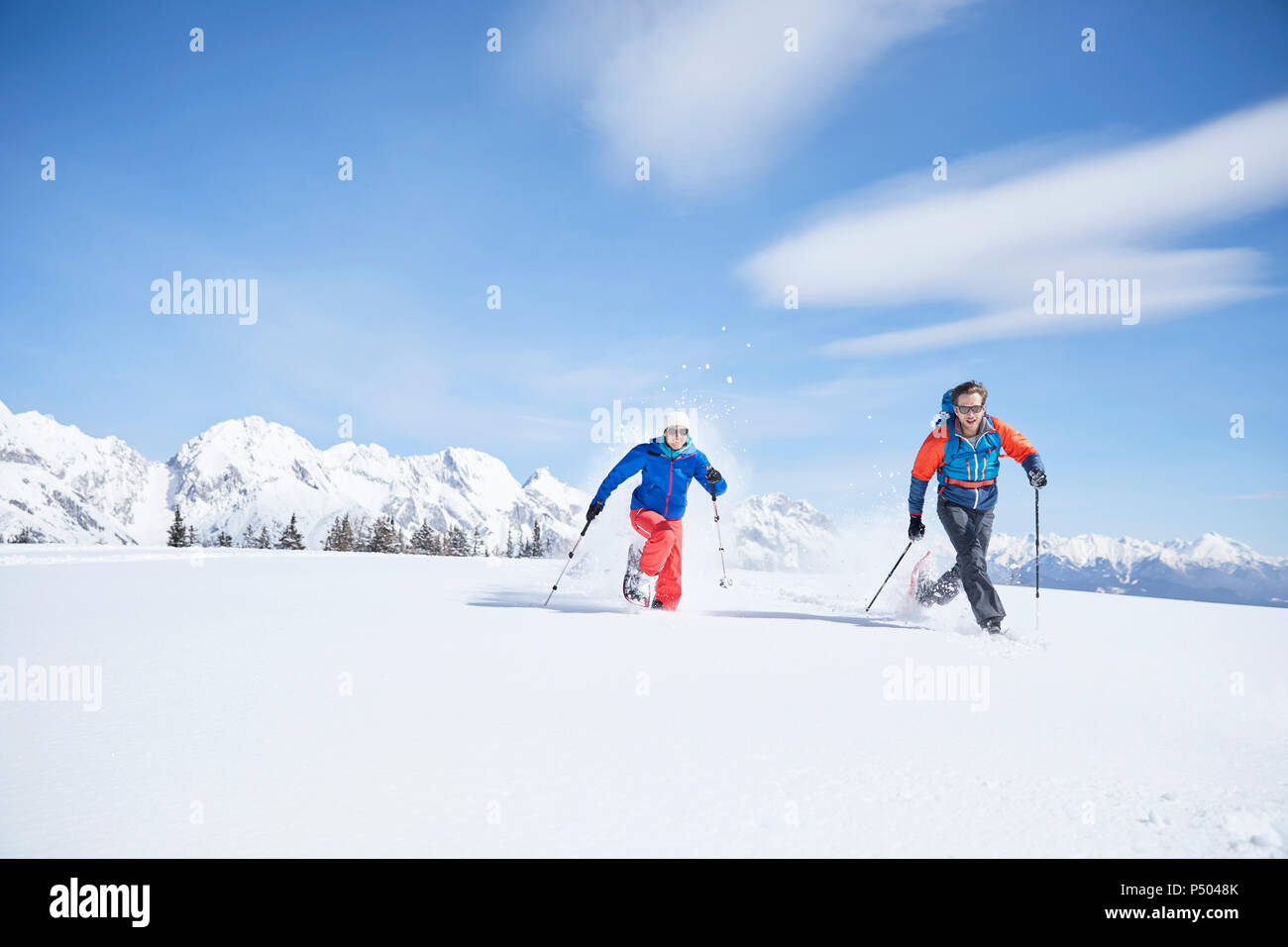 Austria, Tyrol, snowshoe hikers running through snow Stock Photo