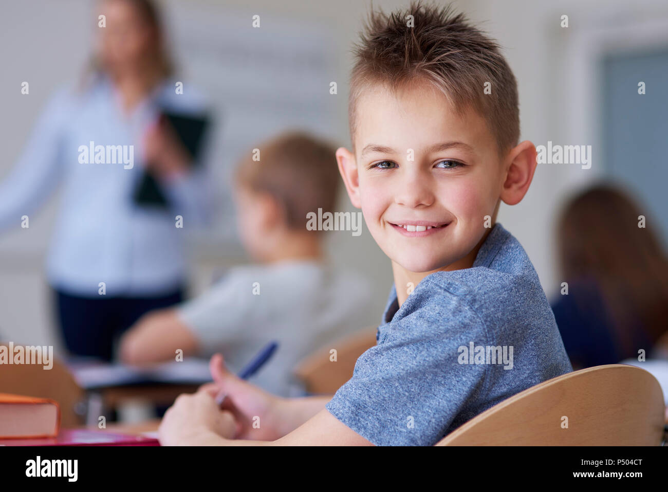 Portrait of smiling schoolboy in class Stock Photo