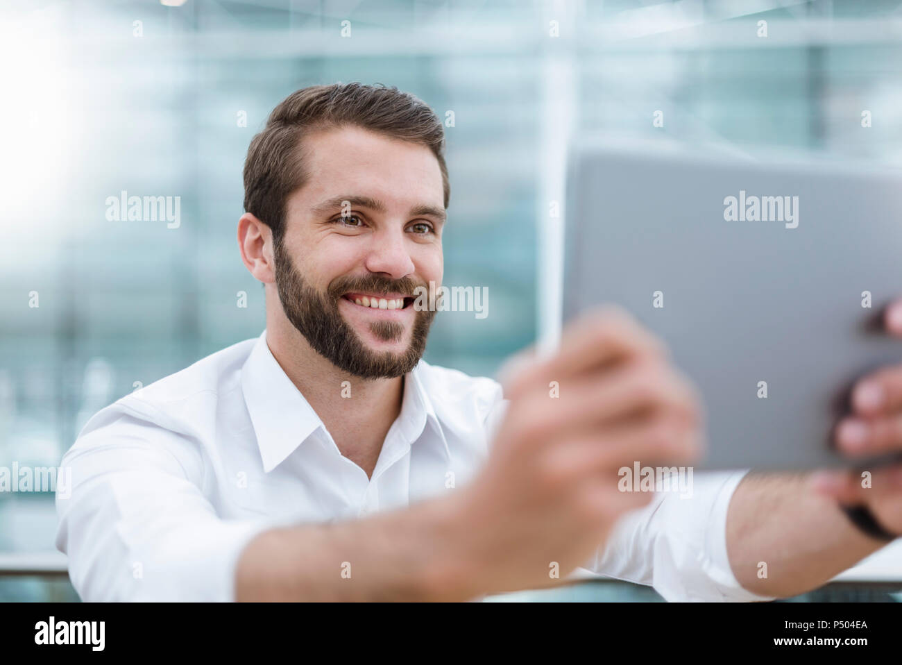 Smiling young man taking a selfie with tablet Stock Photo