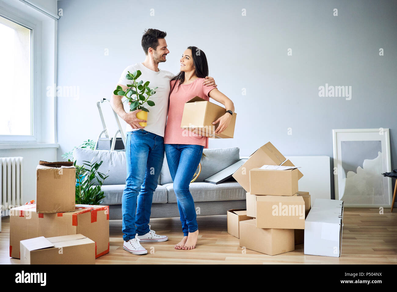 Happy couple unpacking in new apartment Stock Photo