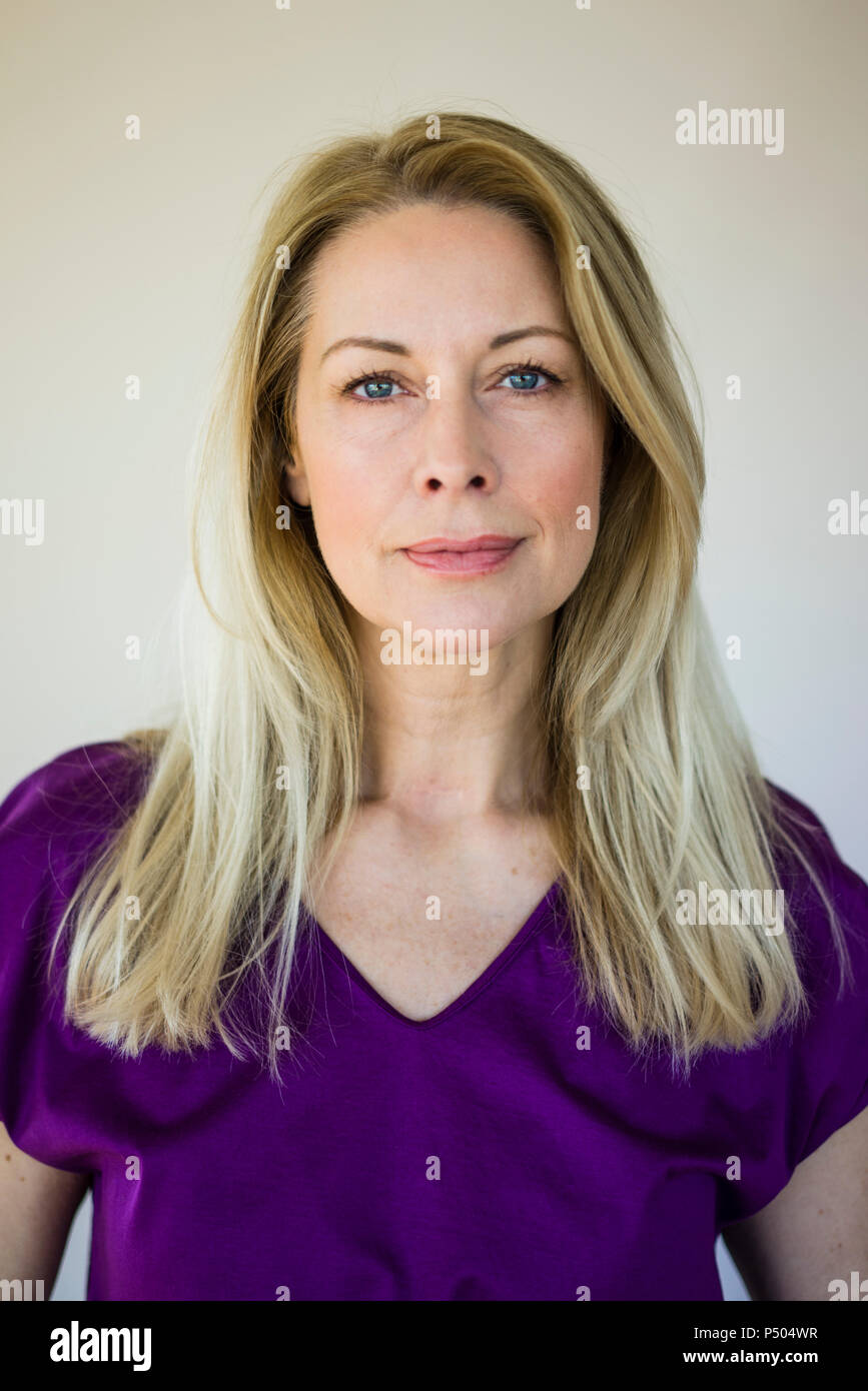 Portrait of blond mature woman wearing purple top Stock Photo