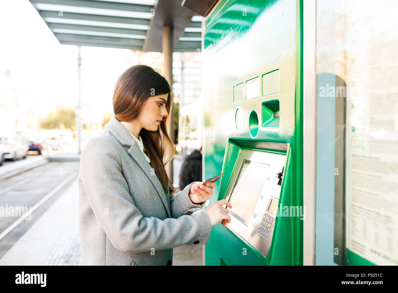 Spain, Barcelona, woman buying ticket from automated machine at  station Stock Photo