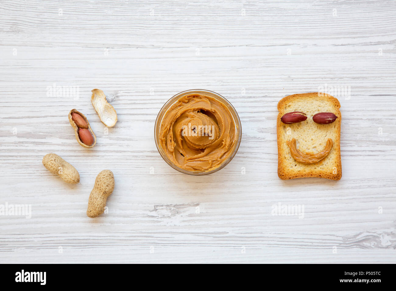 Creative pattern made of toast, peanut butter and peanuts in shells, top view. From above. Stock Photo