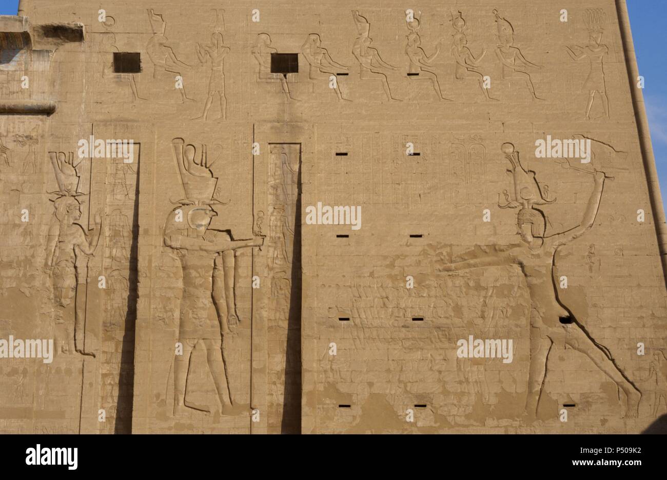 Temple of Horus. The pharaoh Ptolemy XII Neo Dionysos sacrificing prisoners to the god Horus and goddess Hahtor. Main entrance. First pylon. Detail. Edfu. Egypt. Stock Photo