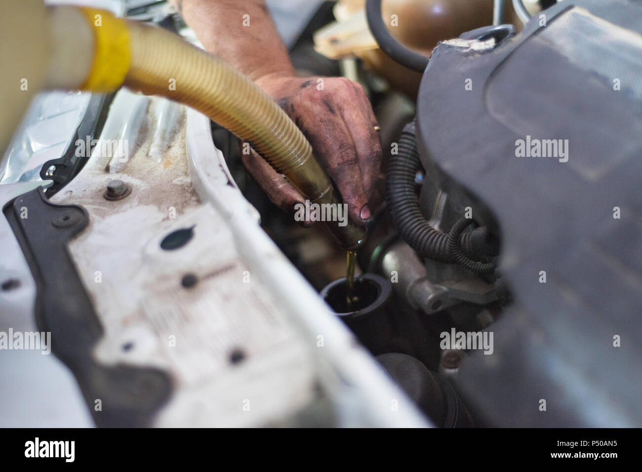 Car mechanic changing engine oil in a dirty engine Stock Photo Alamy