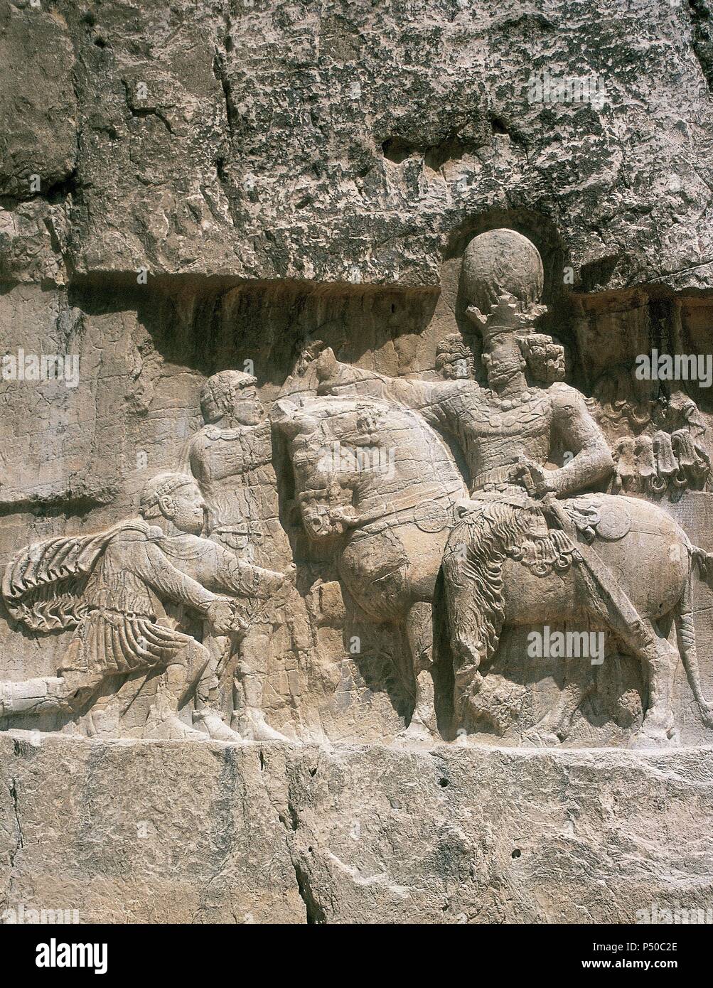 Iran. Naqsh-e-Rustam. Necropolis. Sassanid period. The triumph of Shapur I (241-272) (on horseback). Shapur's victory over  Roman emperors Valerian (kneeling) and Philip the Arab. Stock Photo