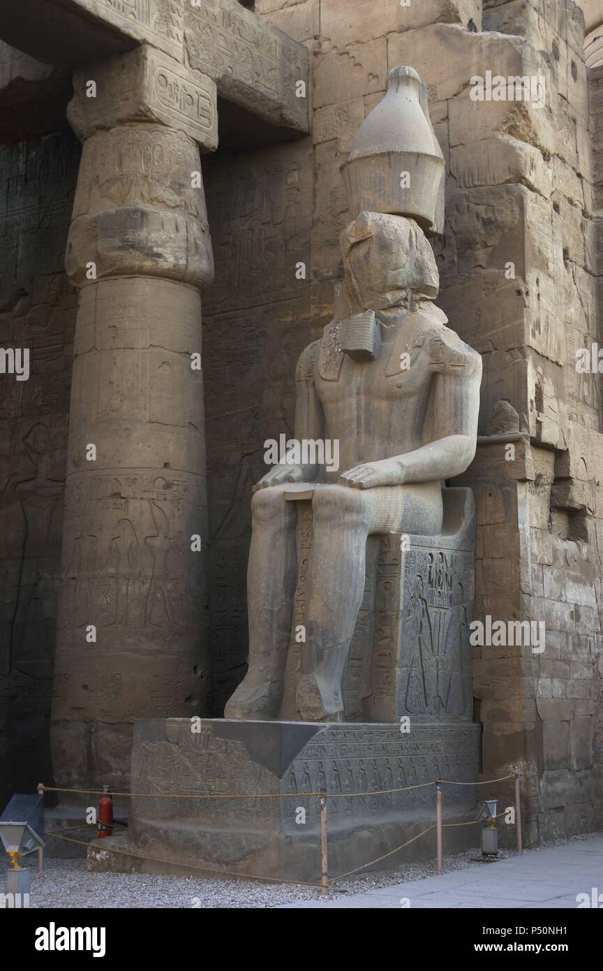 Statue of Amenhotep III (later usurped by Pharaoh Ramses II), between the columns holding the first courtyard. New Kingdom.  Temple of Luxor. Egypt. Stock Photo