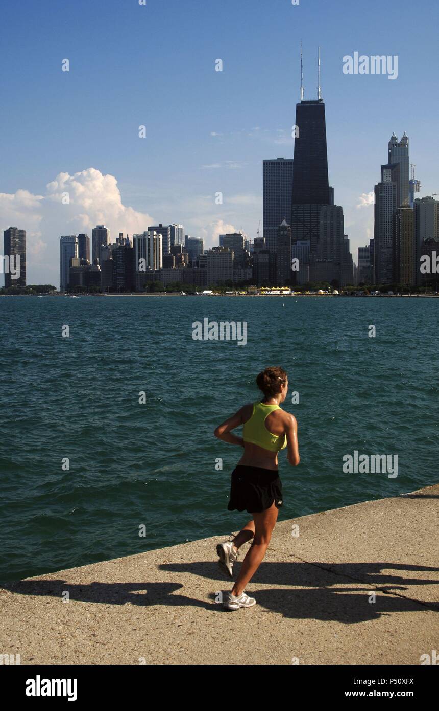 Mujer joven haciendo footing junto al Lago Michigan. Al fondo, los rascacielos del centro de la ciudad. CHICAGO Estado de Illinois. Estados Unidos. Stock Photo