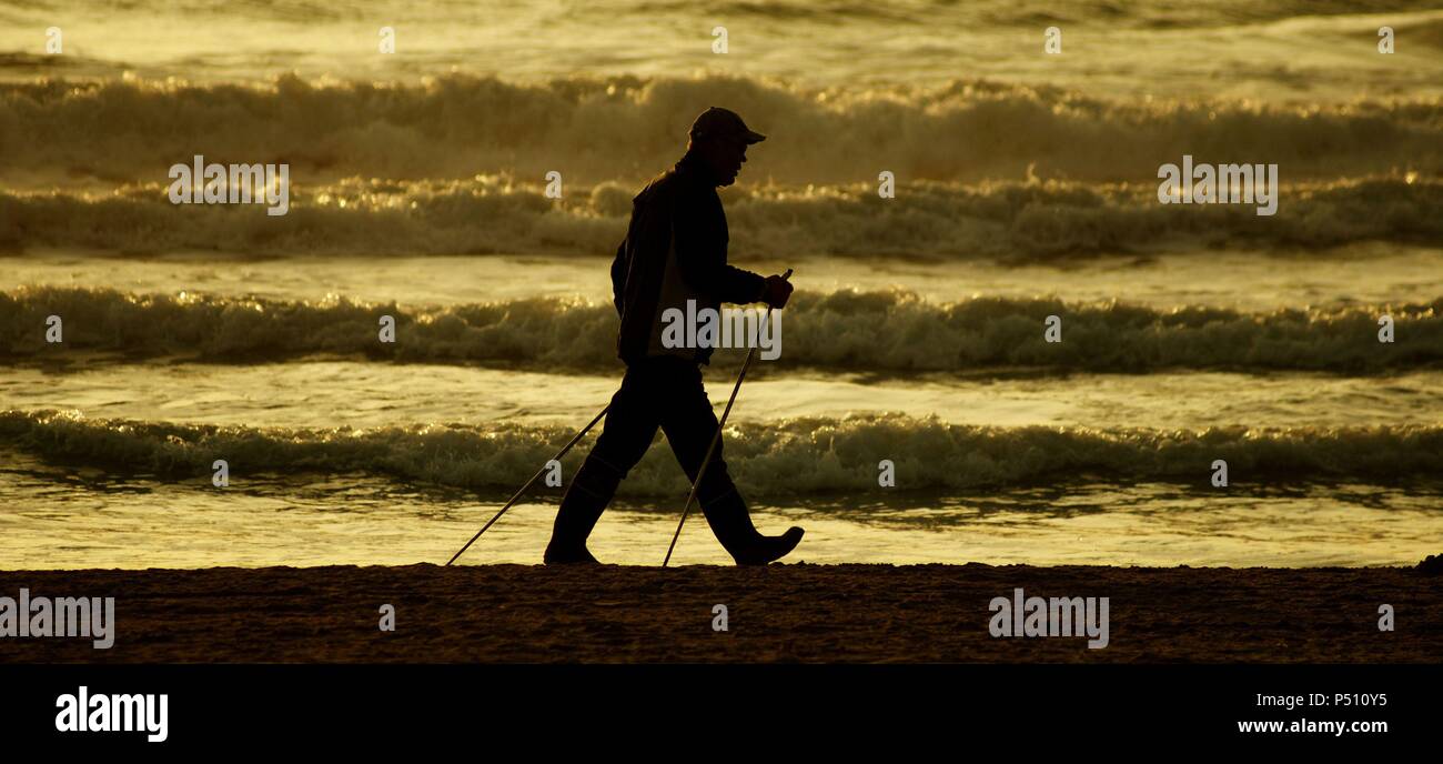 Silhouette of a man walking along the beach. Spain. Stock Photo