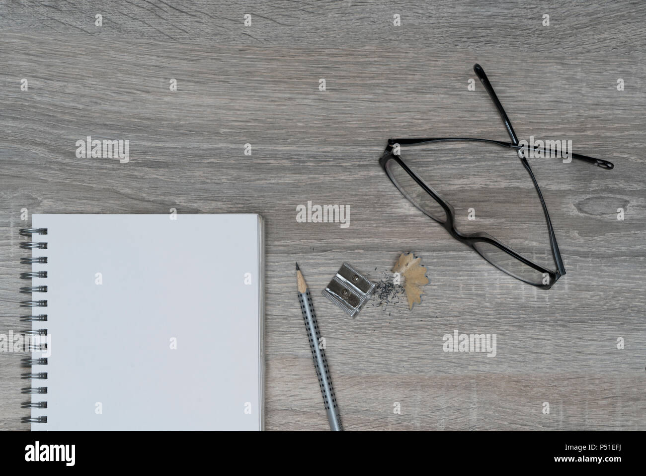 the desk with glasses, a pencil and a clipboard Stock Photo
