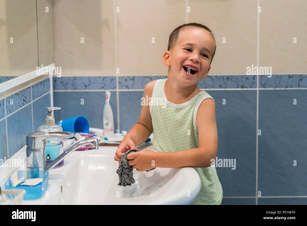 A little boy is washing clothes in the bathroom Stock Photo Alamy