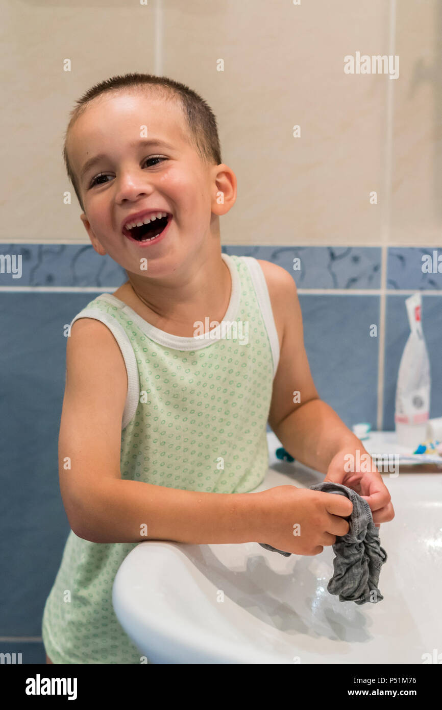 A little boy is washing clothes in the bathroom Stock Photo Alamy