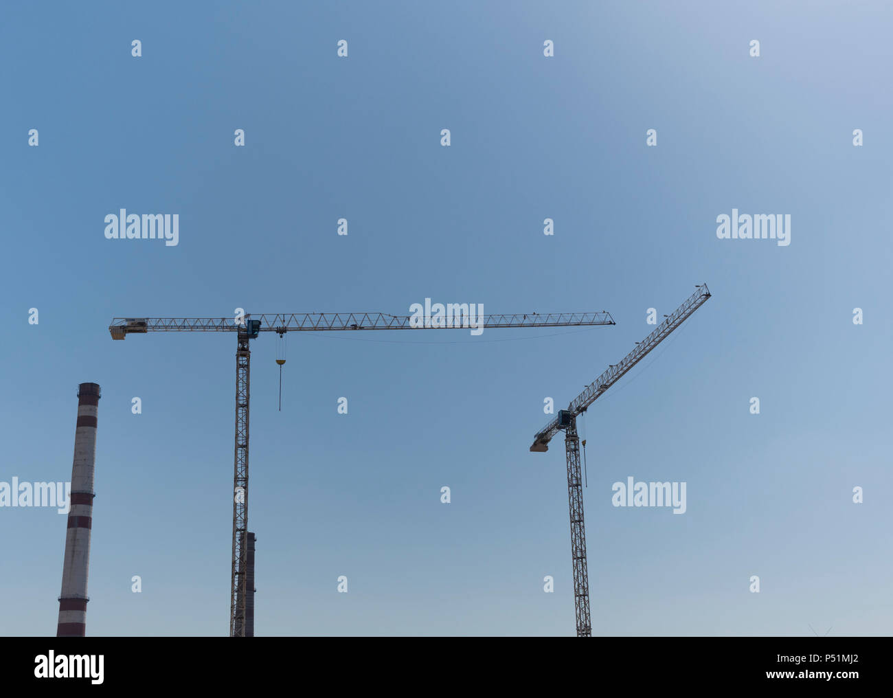 Construction site with two cranes against the sky Stock Photo - Alamy