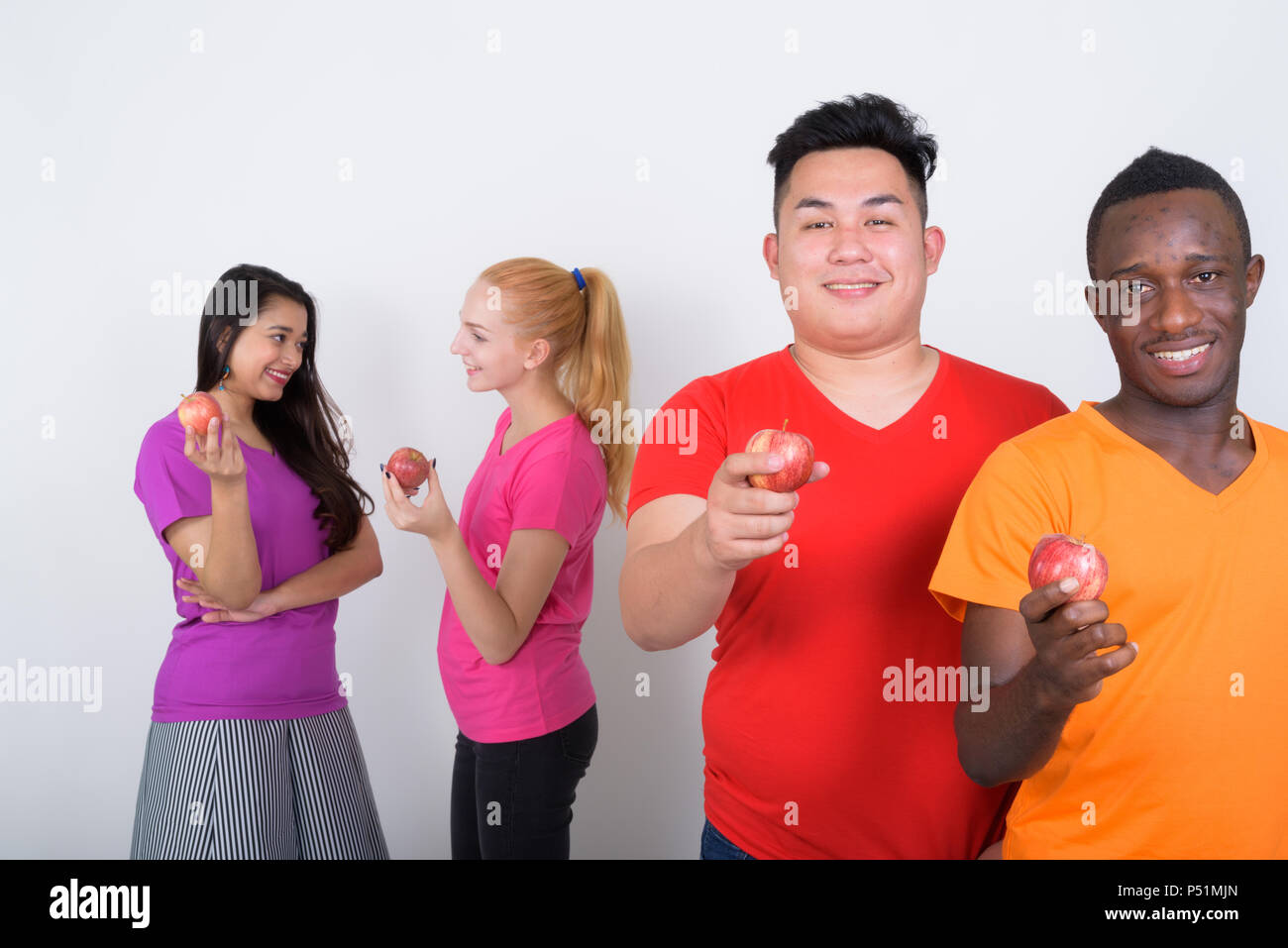 Happy diverse group of multi ethnic friends smiling while holdin Stock Photo