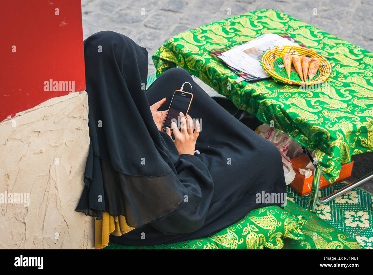 Doha, Qatar Mart 2018 Young arab woman in hijab doing something on
