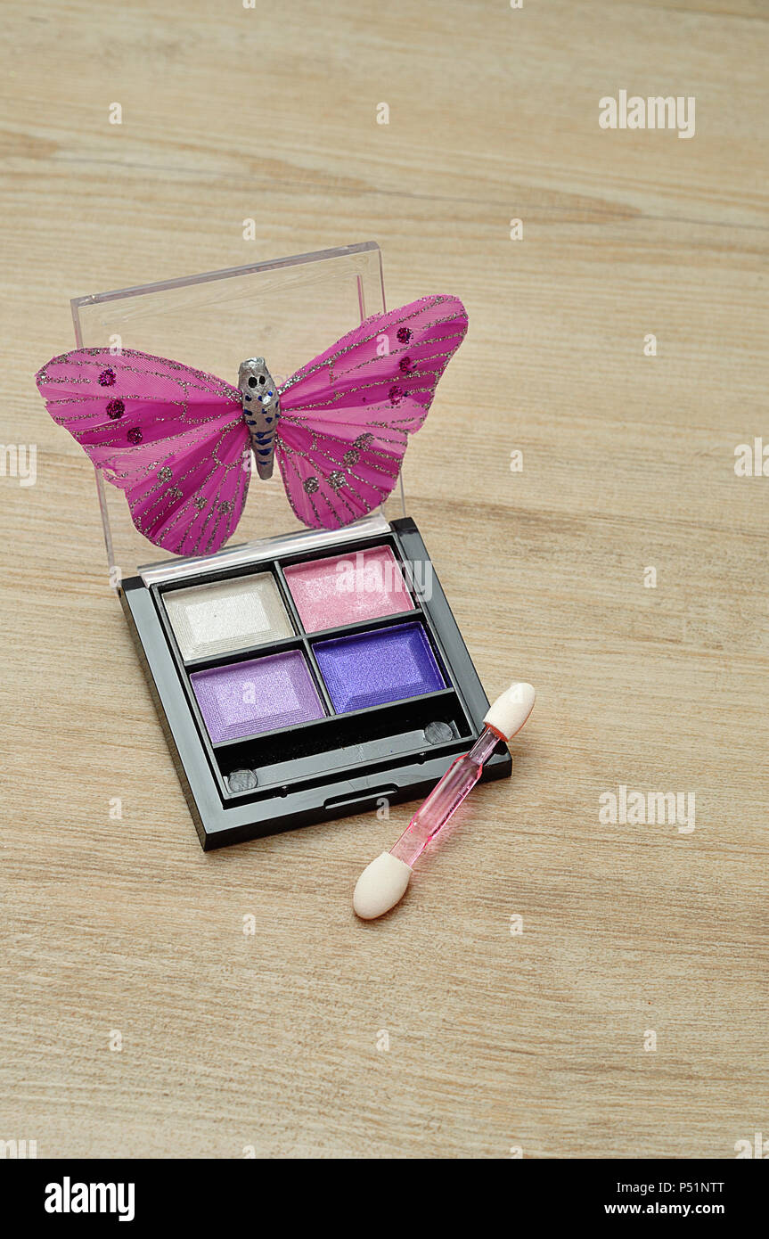 A palette of colorful eye shadow displayed with a silk butterfly Stock Photo