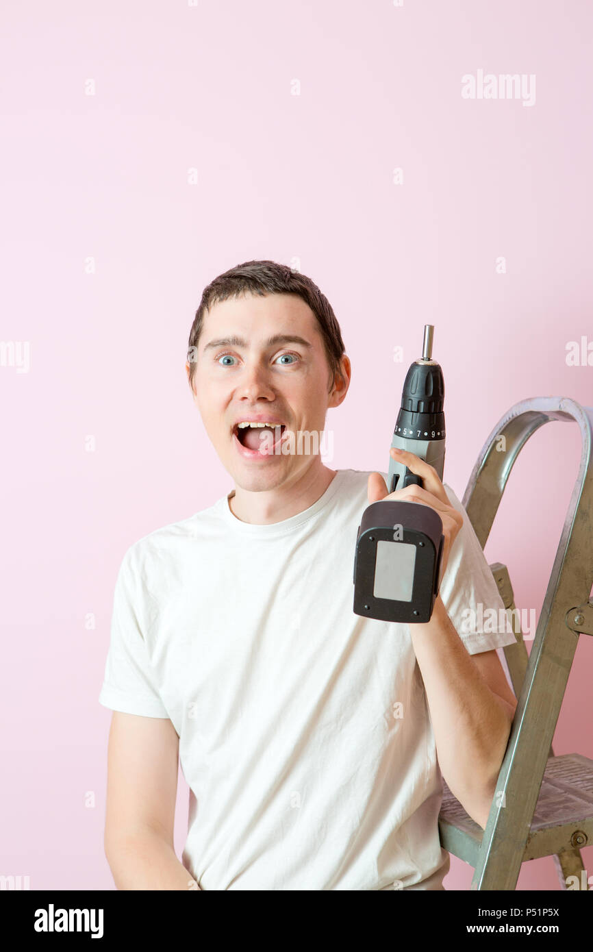Photo of man with drill near ladders Stock Photo Alamy