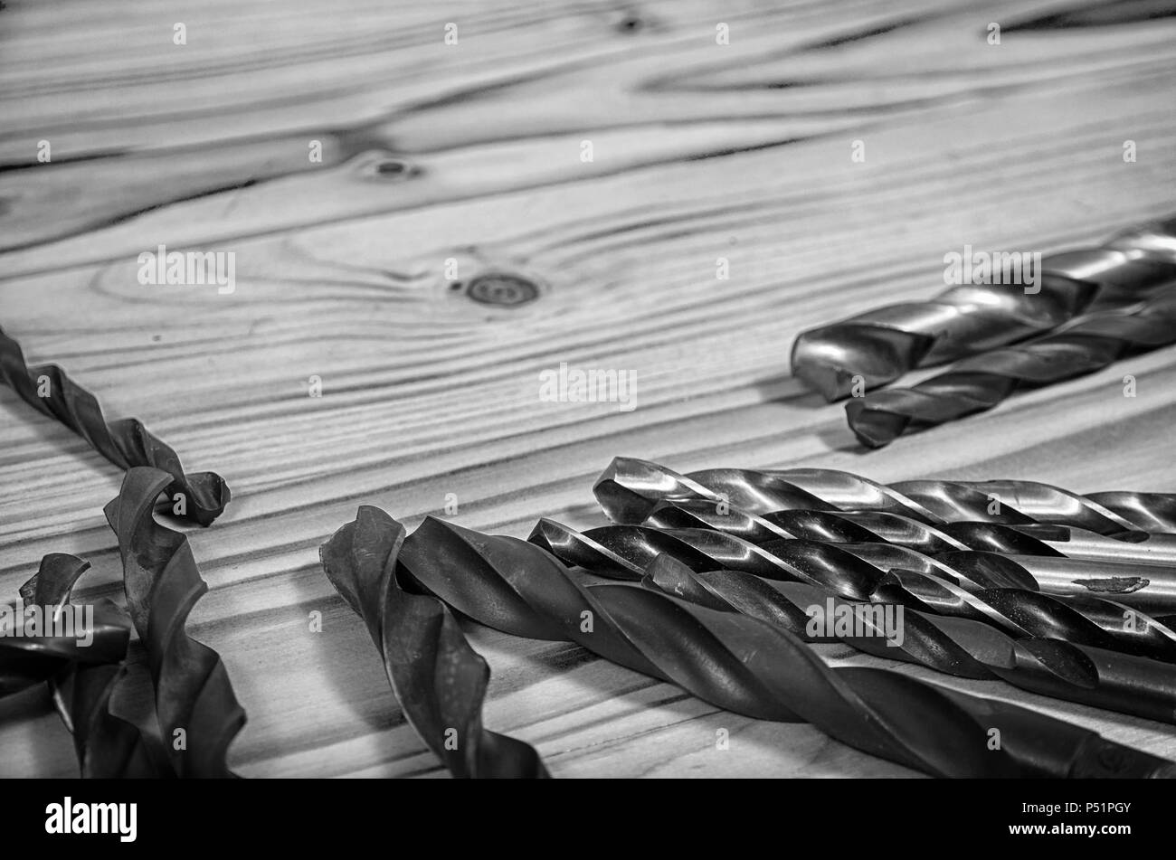 Drills on a wooden table in black and white. Stock Photo