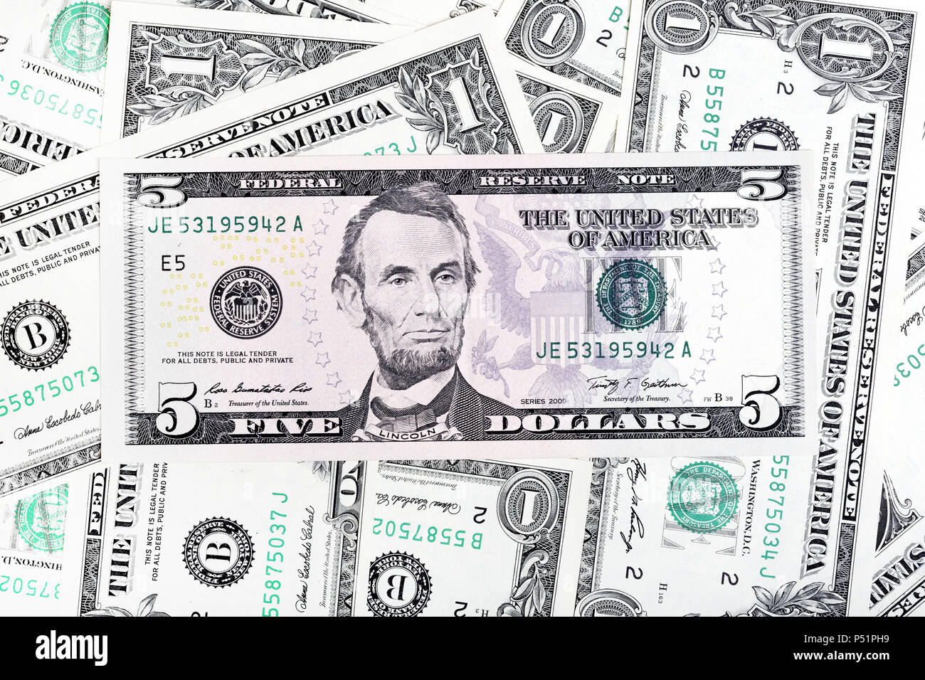 One dollar banknotes and five dollar bill, abstract background. Stock Photo