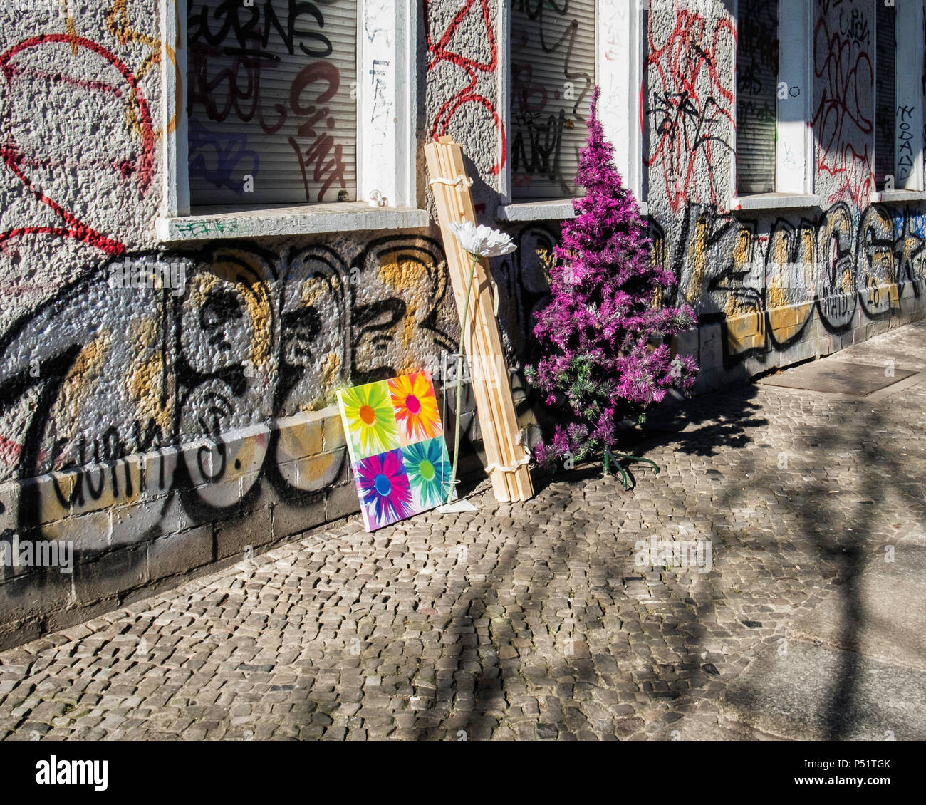 Kreutzigerstrasse, Friedrichshain,Berlin. Street view with wall covered in  graffiti and discarded Christmas tree & picture Stock Photo