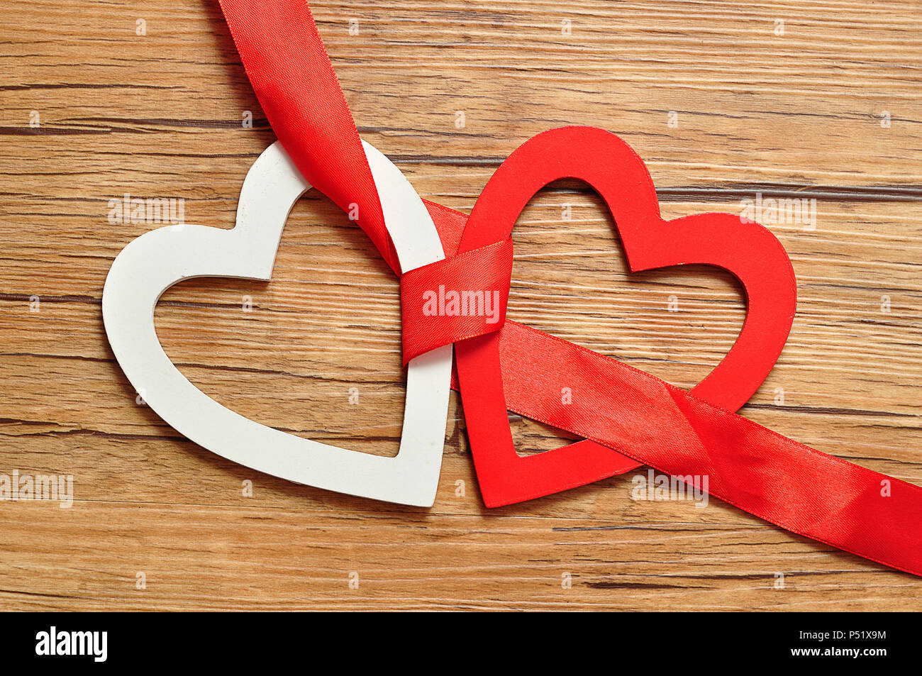 A white and red heart bind together with a red ribbon Stock Photo