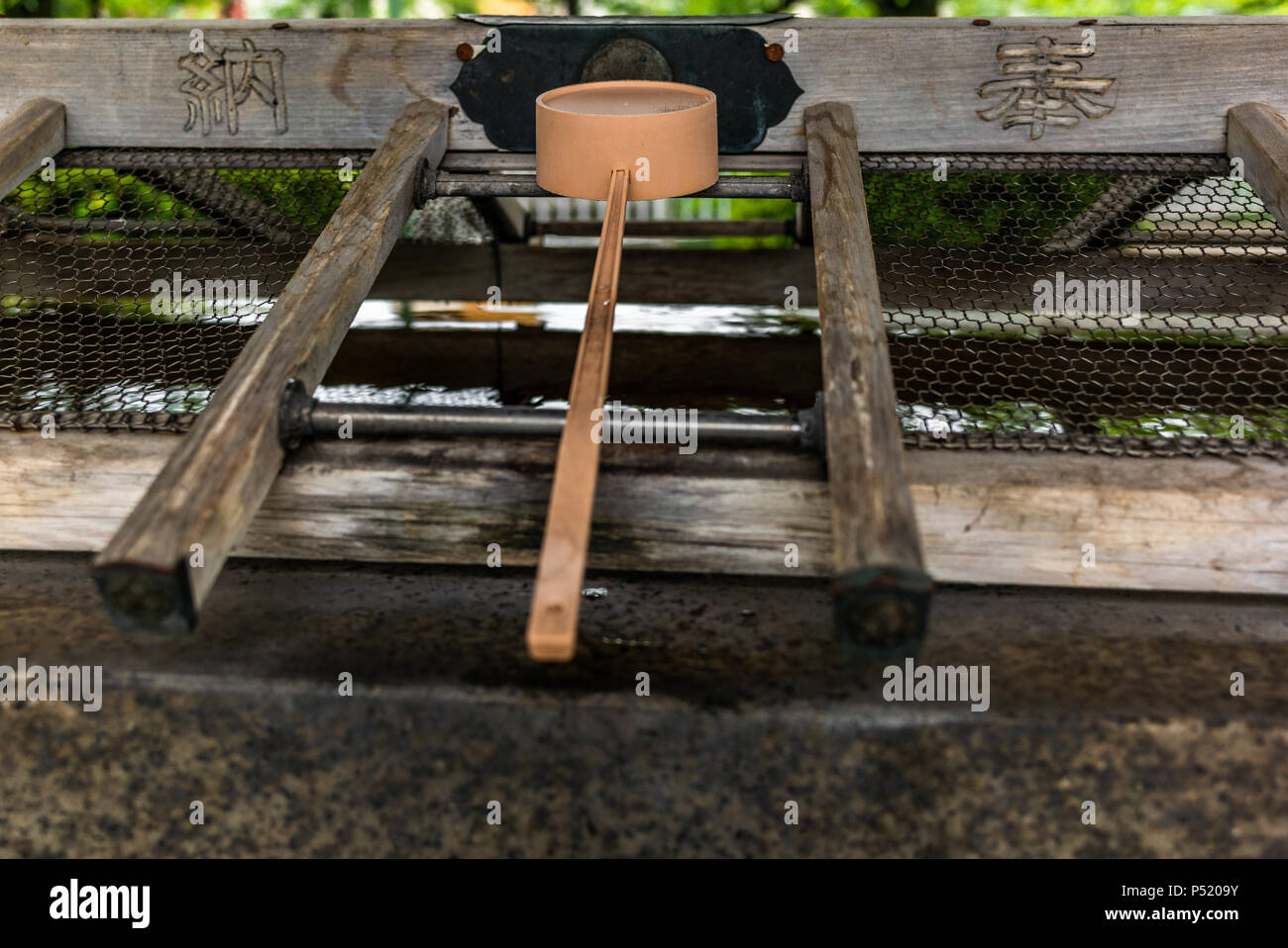 Stillness at the water basin at the entrance of a shrine in Japan for the riual Temizuya purification - 8 Stock Photo