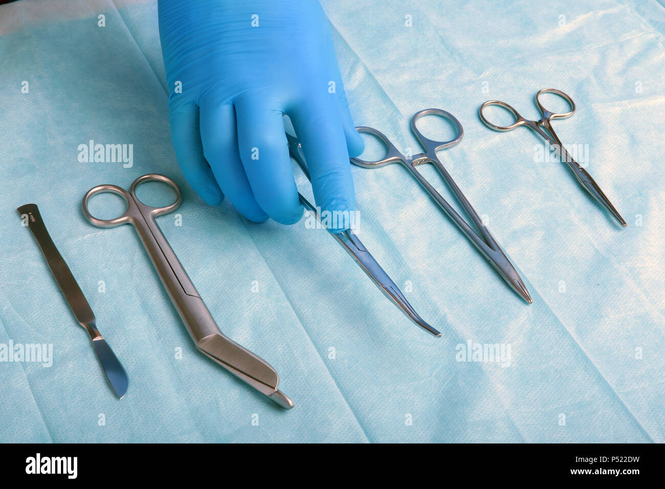 Detail shot of sterilized surgery instruments with a hand grabbing a
