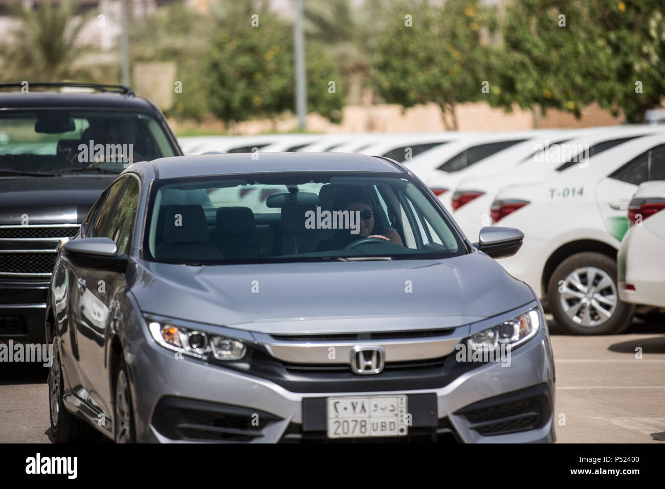 Riyadh, Saudi Arabia. 24th June, 2018. A Saudi woman drives her car on the first day after lifting the driving ban on women, in Riyadh, Saudi Arabia, 24 June 2018. Women in Saudi Arabia got behind the wheel on Sunday after a decades-long ban was lifted as part of a liberalization drive in the conservative kingdom. Credit: Gehad Hamdy/dpa/Alamy Live News Stock Photo
