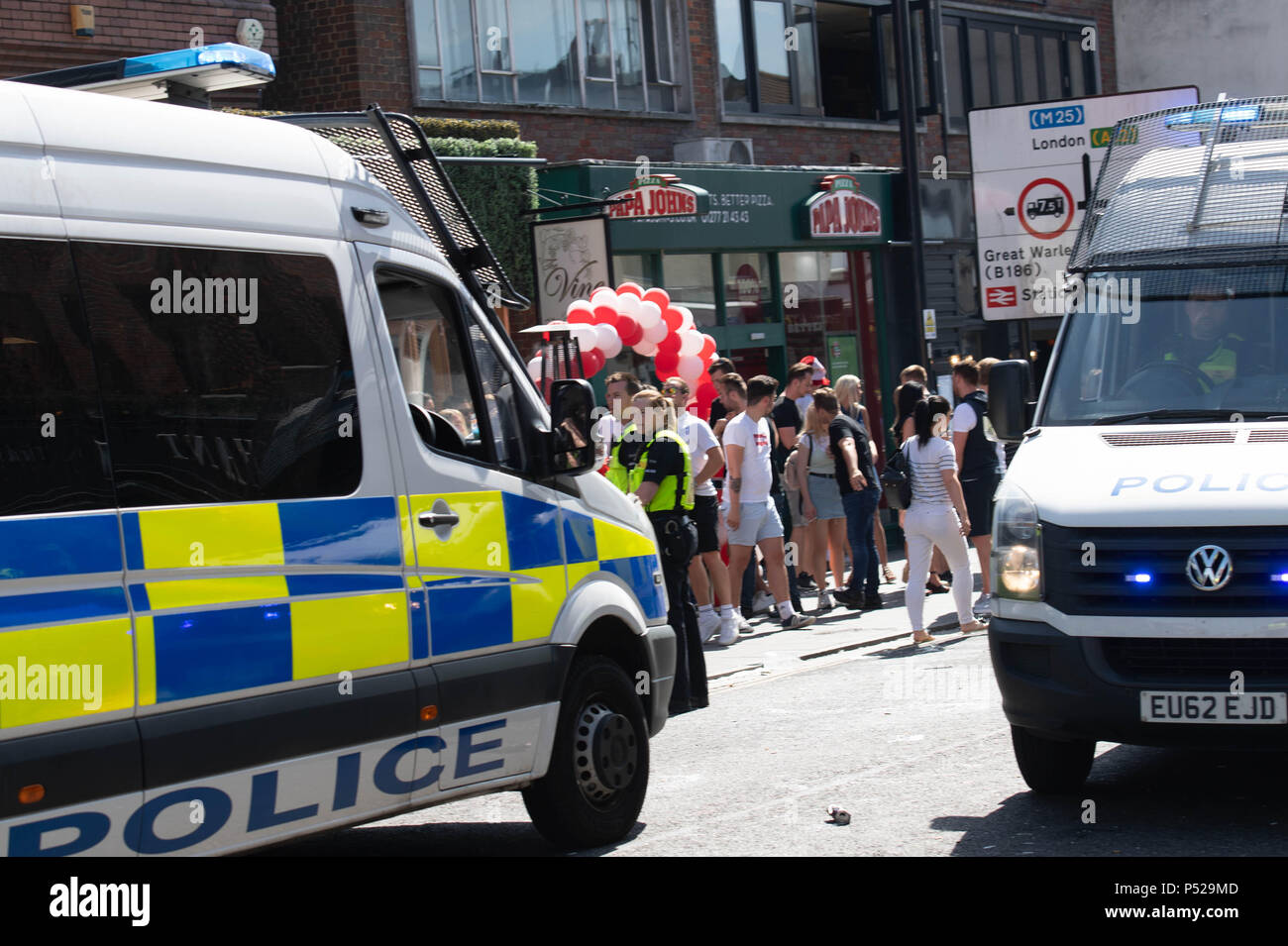 Brentwood, UK. 24 June 2018.  Large scale disorder in Brentwood High Street following England win in World Cup game.  Police required reinforcements, had their hats stolen and when a girl was detained for taking a hat the crowd threw cups and bottles at the police line.  Credit Ian Davidson/Alamy Live News Stock Photo