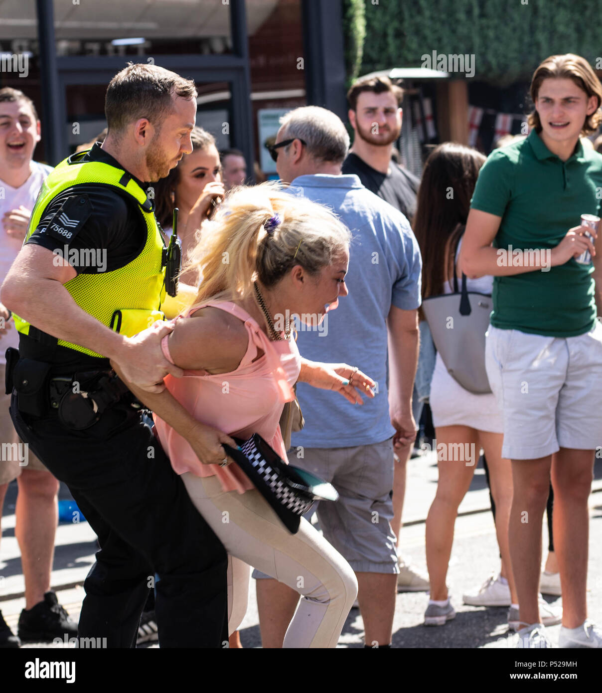 Brentwood, UK. 24 June 2018.  Large scale disorder in Brentwood High Street following England win in World Cup game.  Police required reinforcements, had their hats stolen and when a girl was detained for taking a hat the crowd threw cups and bottles at the police line.  Credit Ian Davidson/Alamy Live News Stock Photo