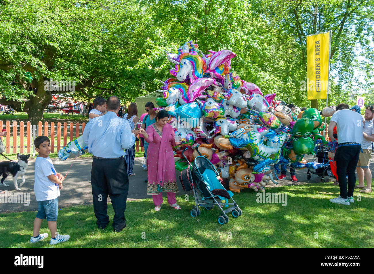 Glasgow, Scotland, UK. 24th June, 2018. A helium balloon seller at Glasgow  Mela, an annual multicultural music festival held in Kelvingrove Park. This  year's performers included Miss Pooja, Akbar Ali, Black Star