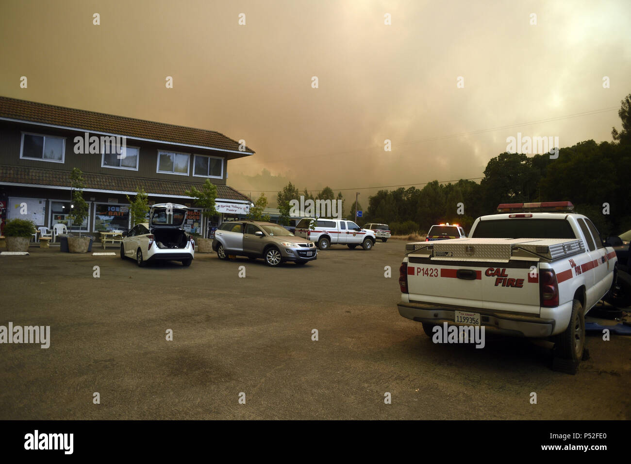 Clearlake Oaks, California, USA. 24th June, 2018. The Pawnee Fire in Lake County continued to show aggressive fire behavior in the early afternoon of Sunday. Fire crews focused on structure protection while helicopters make water drops to assist the strike teams on the ground. Credit: Neal Waters/ZUMA Wire/Alamy Live News Stock Photo