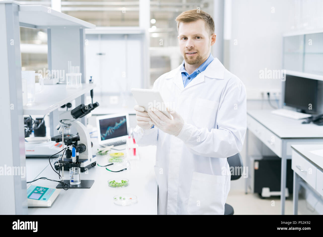 Scientist standing with tablet in laboratory Stock Photo