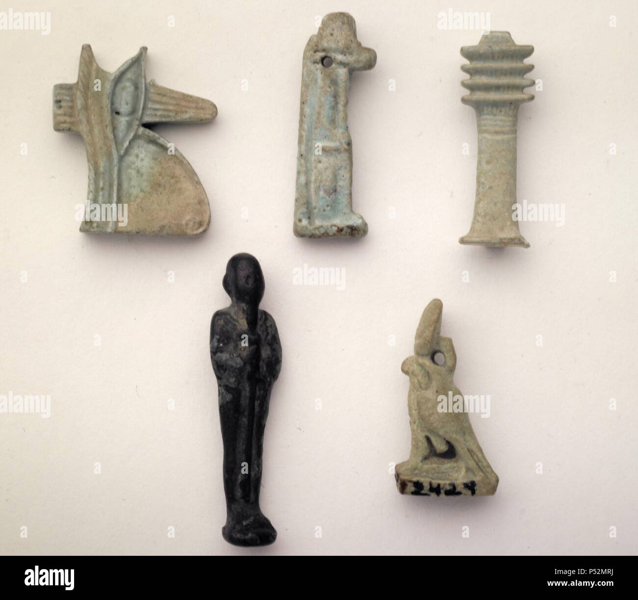Madrid, M.A.N. Arte Egipcio. Baja Época. Procedencia desconocida. Colección T.Asensi.  2293: Amuleto de Udyat, ojo sagrado de Horus. Fayenza. (alt.2.25, anch.0.5). s.VI-III a.c.   2238: Amuleto de Anubis, dios funerario, protector de la necrópolis y los difuntos. (alt.3.1, anch.0.7) s.VI-III a.c.  2475: Amuleto de fayenza del pilar Dyed, símbolo de Osiris (la estabilidad del mundo, los seres, su duración). Alt.3, anch.0,.5. s.VI-III a.c.   2171:Amuleto de bronce del Dios Ptah, divinidad principal de Menfis, Dios creador de la palabra y padre de los dioses, de todas las cosas, patrón de orfebre Stock Photo
