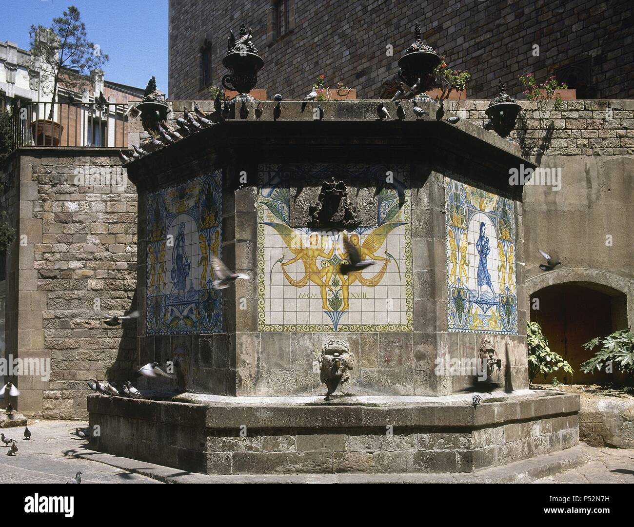 Fountain of the Puerta del Angel. Originally Gothic, was rebuilt in neoclassical style. In 1918 he added the ceramic murals by Josep Aragay. Barcelona. Catalonia. Spain. Stock Photo