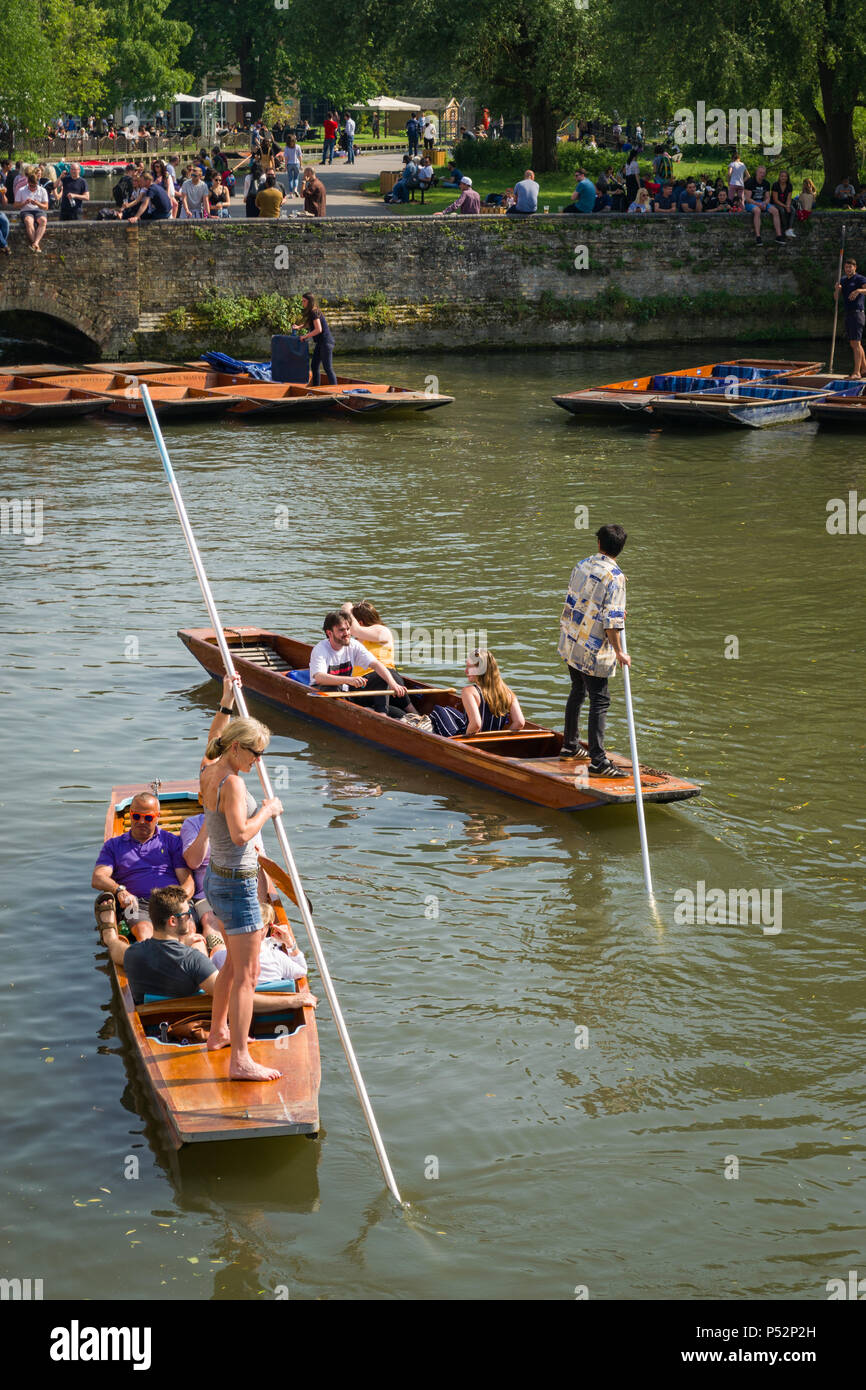 People on punt boats punting on the river Cam as people walk alongside it on a sunny Summer afternoon, Cambridge, UK Stock Photo