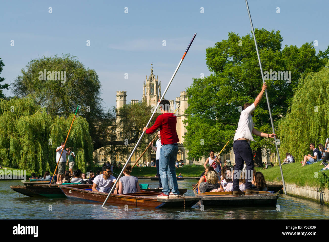 People on punt boats punting on the river Cam with St. Johns College university in background on a sunny Summer afternoon, Cambridge, UK Stock Photo