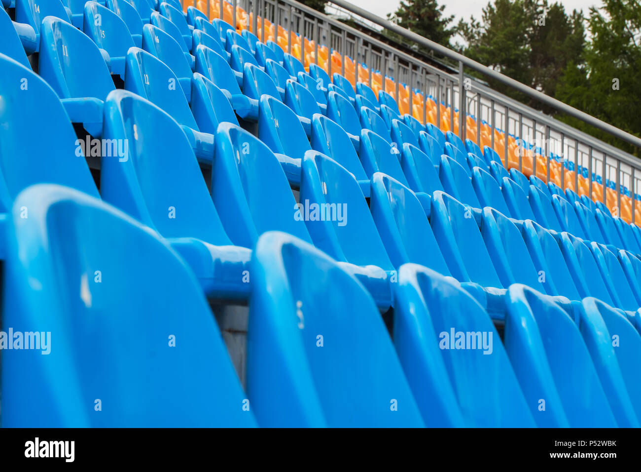 Rows of blue and orange chairs on a soccer stadium Stock Photo