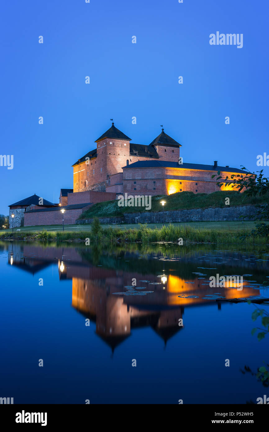 Beautiful view of lit 13th century Häme Castle and its reflections on lake Vanajavesi in Hämeenlinna, Finland, at night. Stock Photo