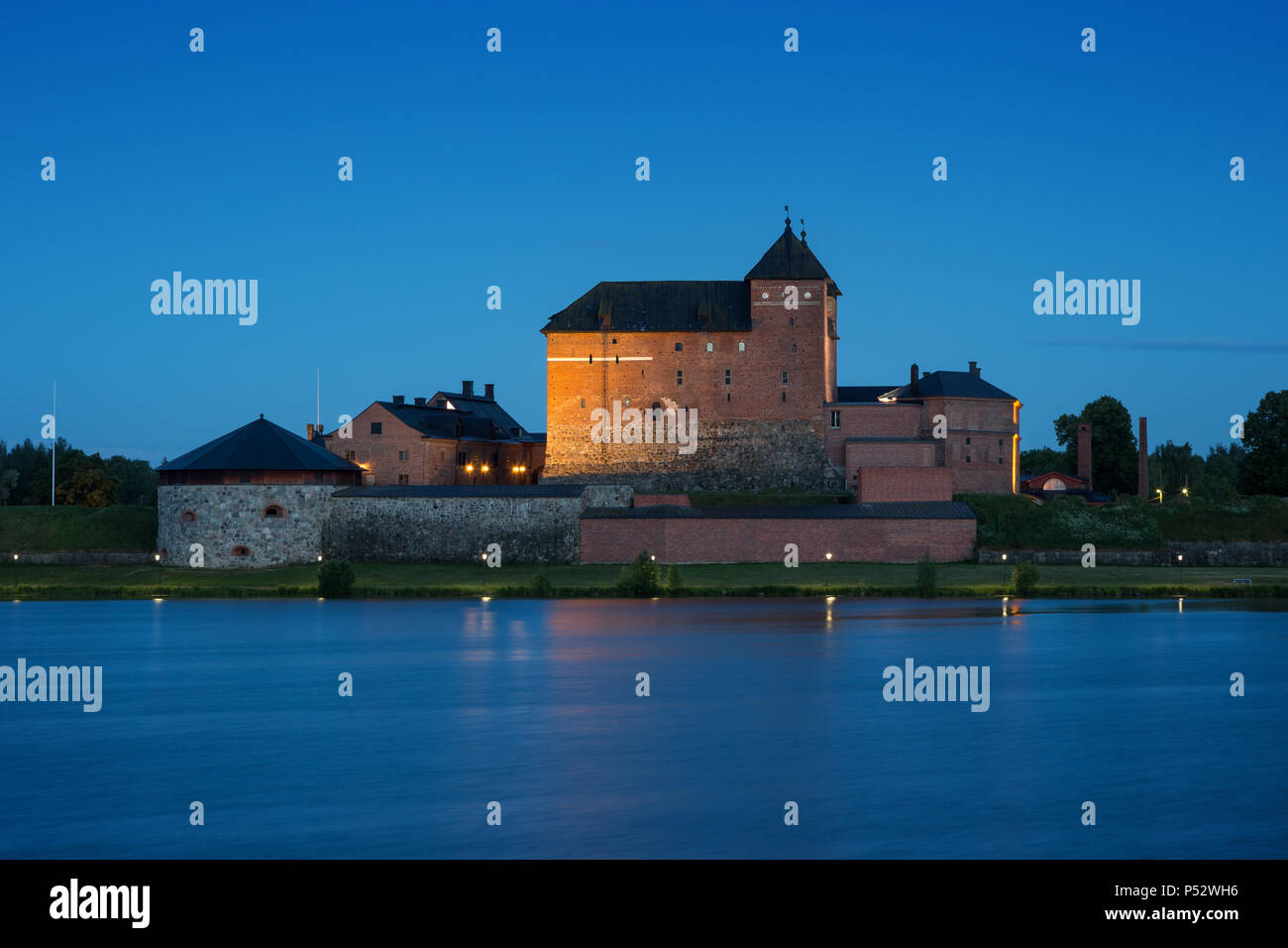 Beautiful view of lit 13th century Häme Castle and lake Vanajavesi in Hämeenlinna, Finland, in the evening. Stock Photo