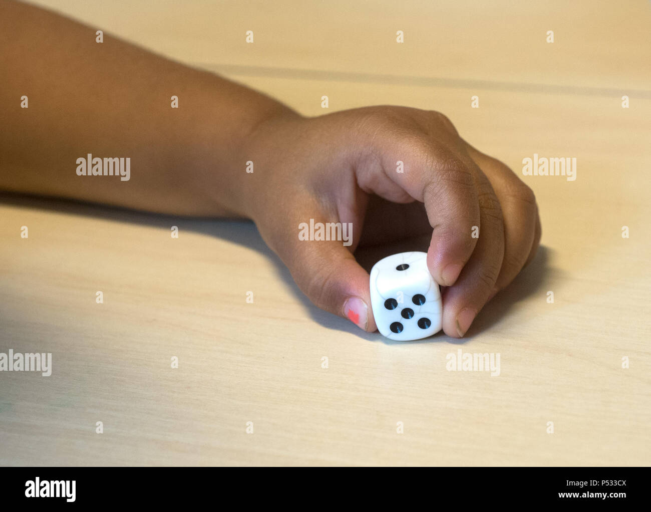 Children playing with a dice Stock Photo