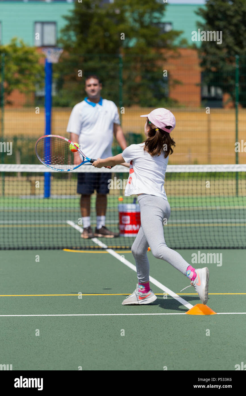 Children's tennis coaching session / lesson taking place on a fullsize