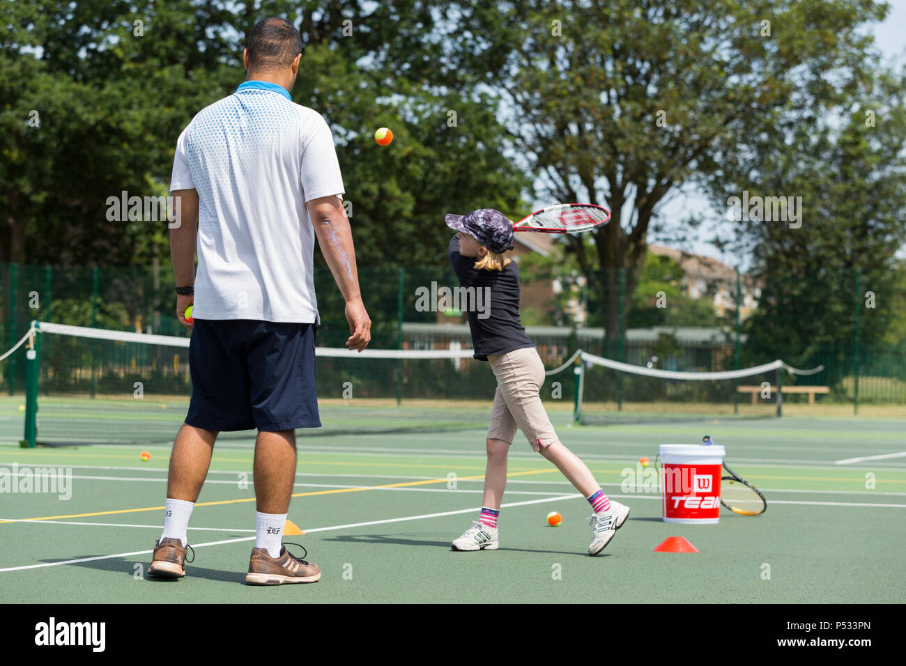 Children's tennis coaching session / lesson taking place on a fullsize