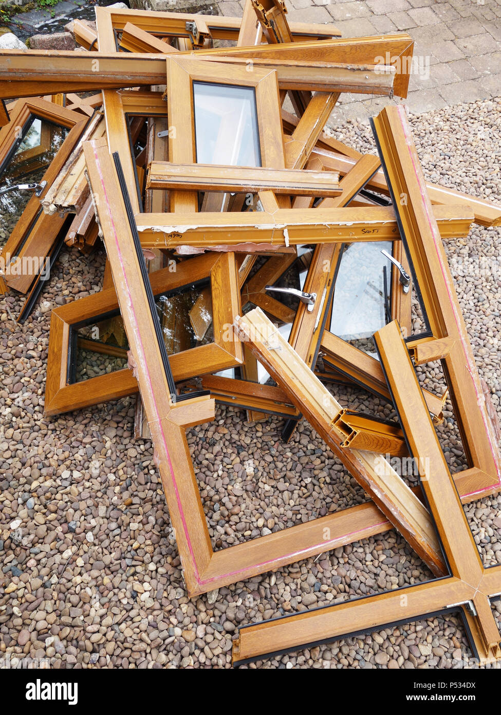 A pile of scrapped plastic wood effect ex window frames being replaced with solid oak. More