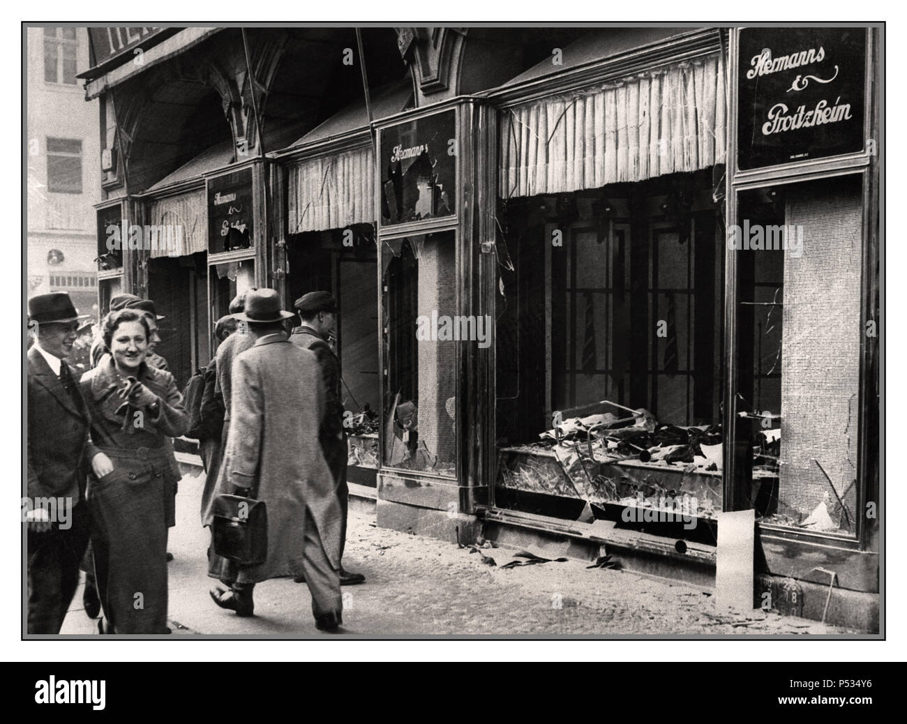 KRISTALLNACHT BERLIN JEWISH SHOP FRONT Shattered storefront of a Jewish-owned shop destroyed by Nazi NSDAP sympathisers during Kristallnacht (the 'Night of Broken Glass'). Berlin, Germany, November 10, 1938. Passing onlookers apparently smiling in appreciation...Berlin Germany Stock Photo