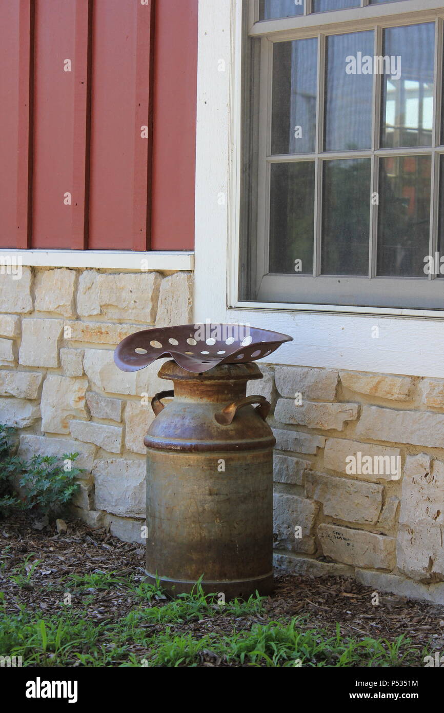 Tractor seat welded to the top of a milk can Stock Photo Alamy