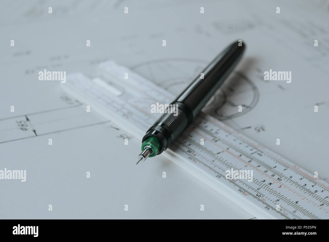 Technical pen (rapidograph) on slide rule and technical drawing Stock Photo