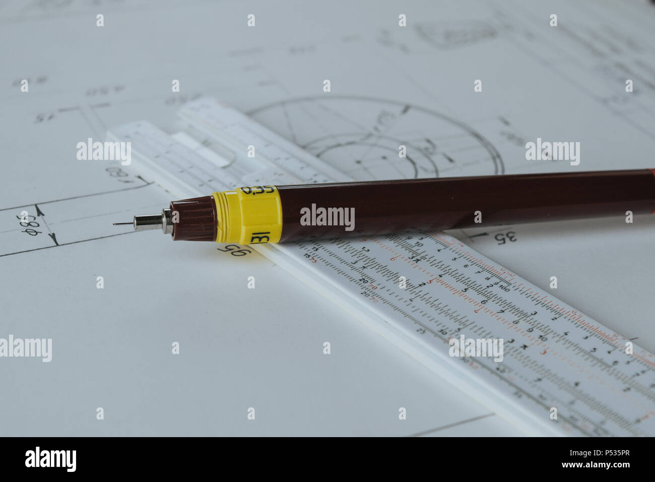 Technical pen (rapidograph) on slide rule and technical drawing Stock Photo